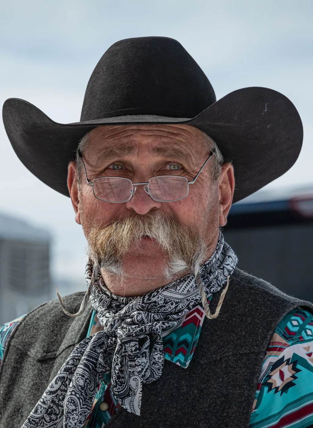 Kevin in a black cowboy hat, glasses, and patterned Western scarf